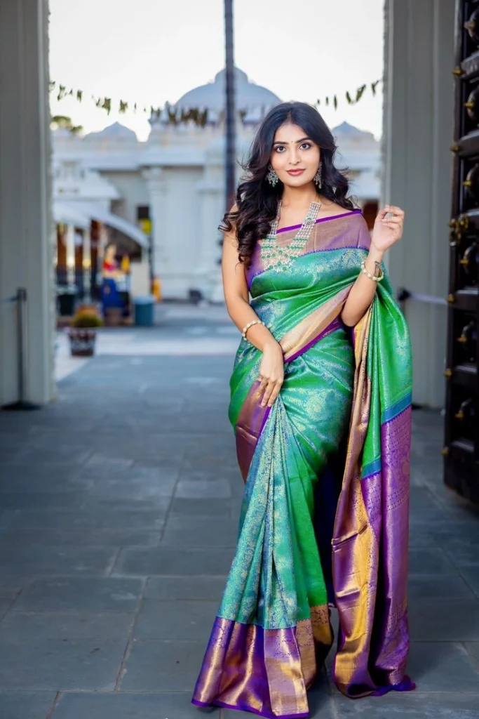 Woman wearing green and purple pure silk saree with gold zari border in traditional South Indian style